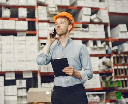 promyslennyi-rabocii-v-pomesenii-na-zavode-biznesmen-s-oranzevoi-kaskoi-muzcina-v-goluboi-rubaske-scaled